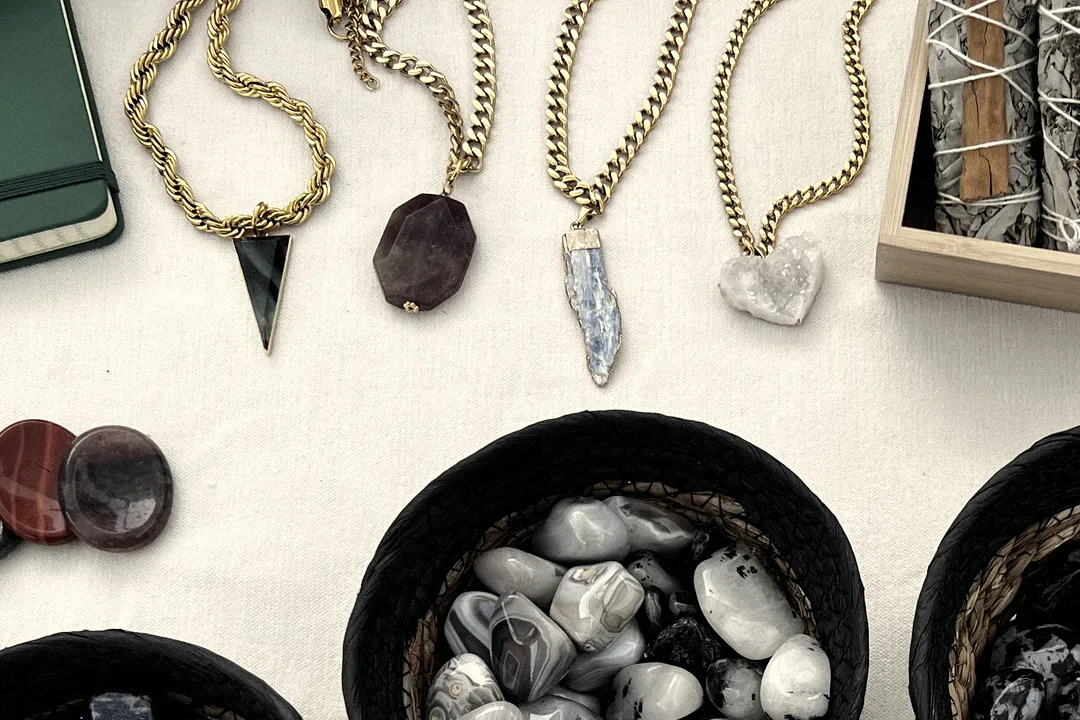 More Drop 001 necklaces laid out on the market table beside bowls of loose stones
