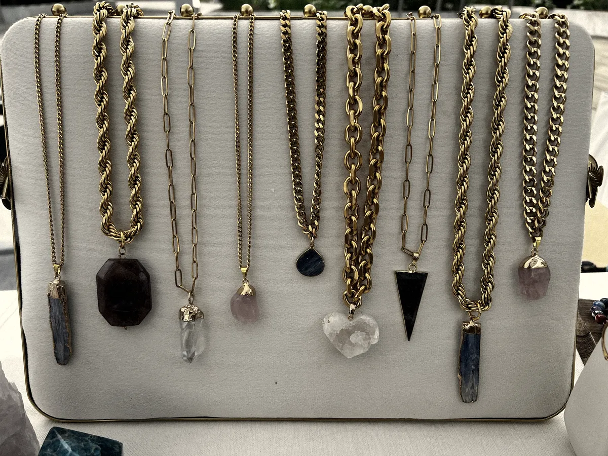 Nine chains hanging on a white display board at an outdoor market